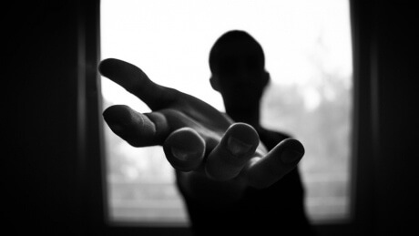 image of person standing with outstretched hand