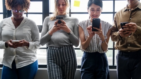 group of people looking at smartphone screens